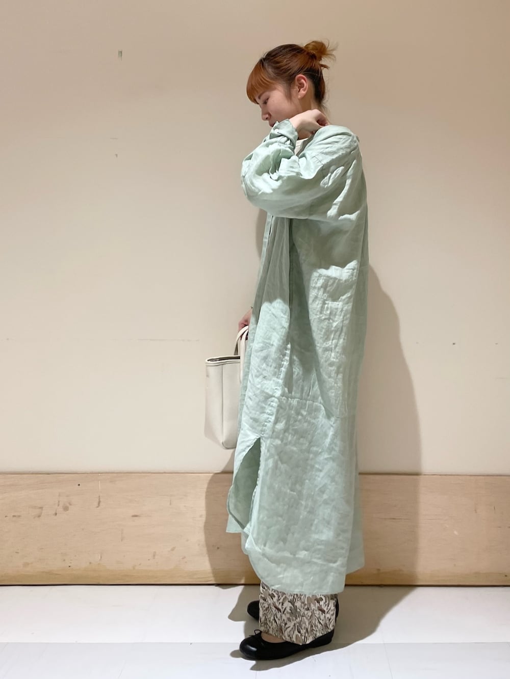 グリーン系のワンピース、ホワイト系のTシャツ/カットソー、ホワイト系のトートバッグを着用したレディースの春コーディネートの3枚目の写真