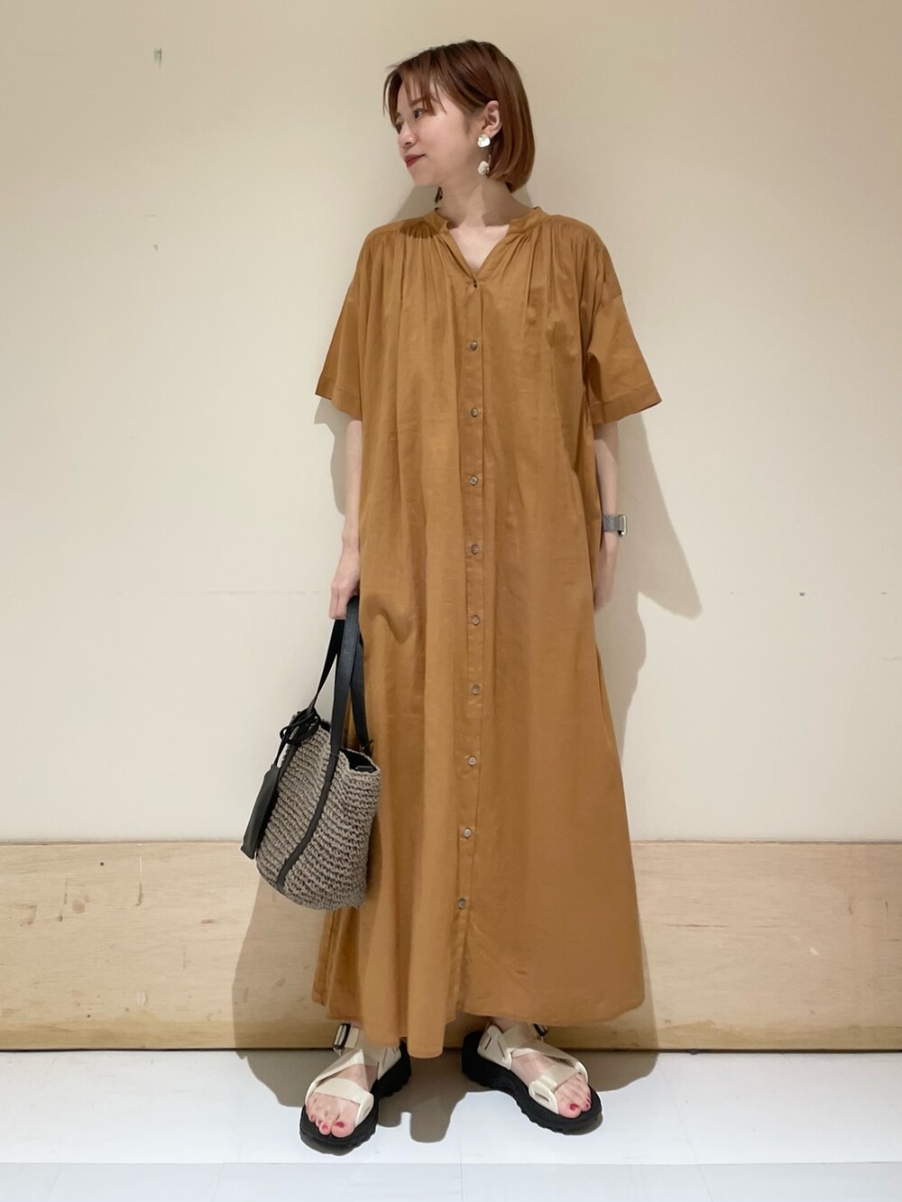 ブラウン系のワンピース、ホワイト系のサンダル、グレー系のトートバッグを着用したレディースの夏コーディネートの3枚目の写真