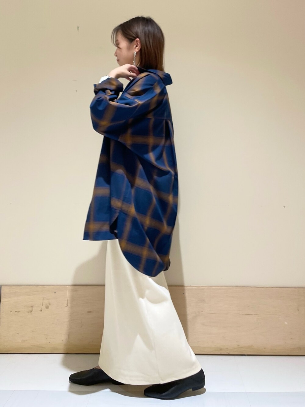 ベージュ系のスカート、ブラック系のパンプス、ブラック系のショルダーバッグを着用したレディースの秋コーディネートの4枚目の写真