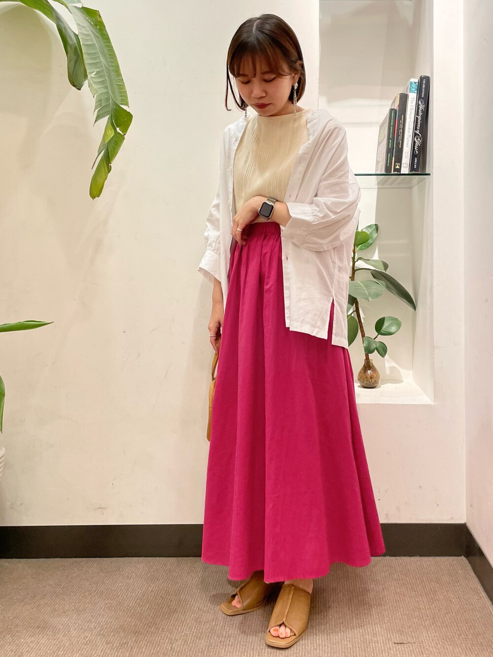 ピンク系のスカート、ホワイト系のシャツ/ブラウス、ホワイト系のニット/セーターを着用したレディースの夏コーディネートの2枚目の写真