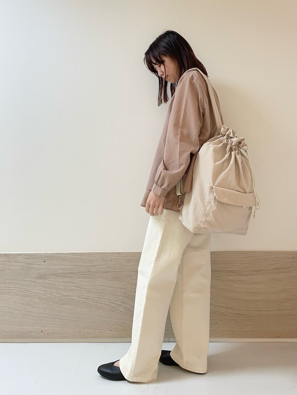 ベージュ系のデニムパンツ、ブラック系のパンプス、ピンク系のバックパック/リュックを着用したレディースの春コーディネートの4枚目の写真