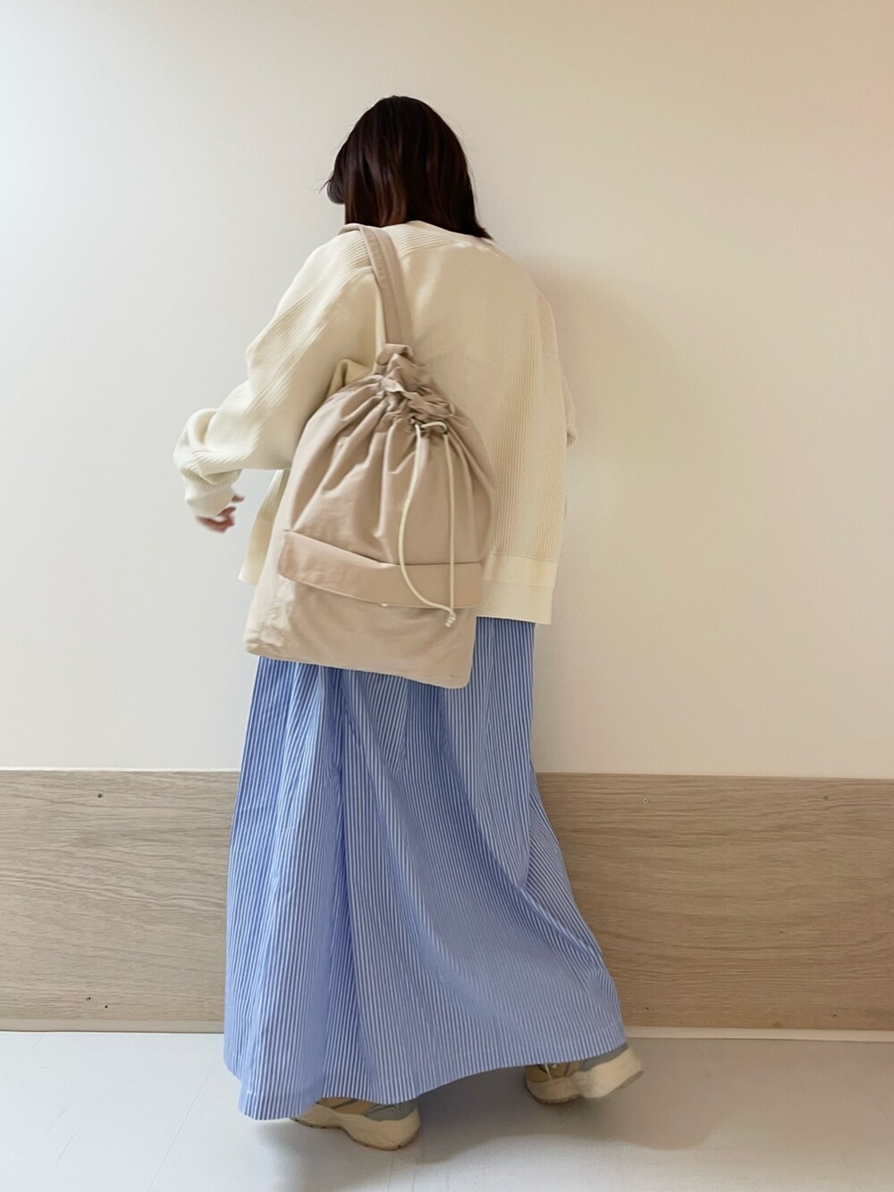 ホワイト系のカーディガン/ボレロ、ベージュ系のスニーカー、ブルー系のワンピースを着用したレディースの春コーディネートの5枚目の写真