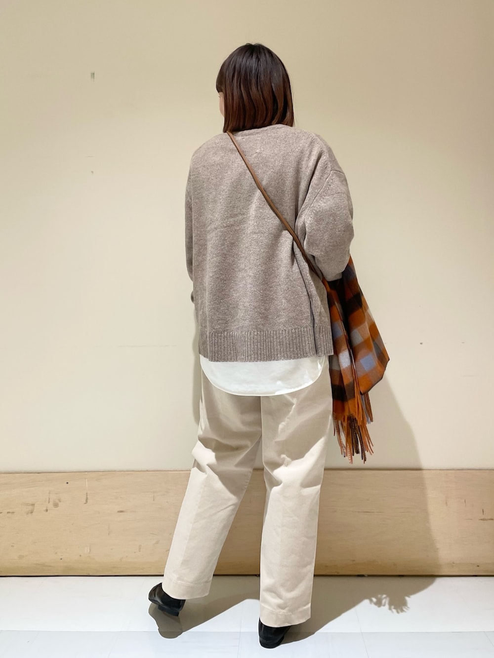 ホワイト系のTシャツ/カットソー、ブラウン系のニット/セーター、ベージュ系のその他パンツを着用したレディースの冬コーディネートの7枚目の写真