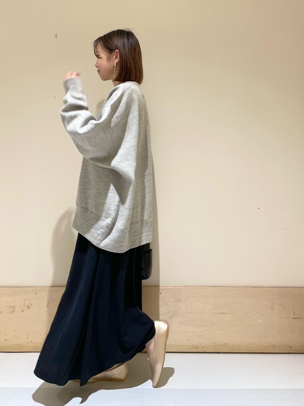 ブラック系のトートバッグ、ゴールド系のパンプス、グレー系のスウェットを着用したレディースの秋コーディネートの5枚目の写真