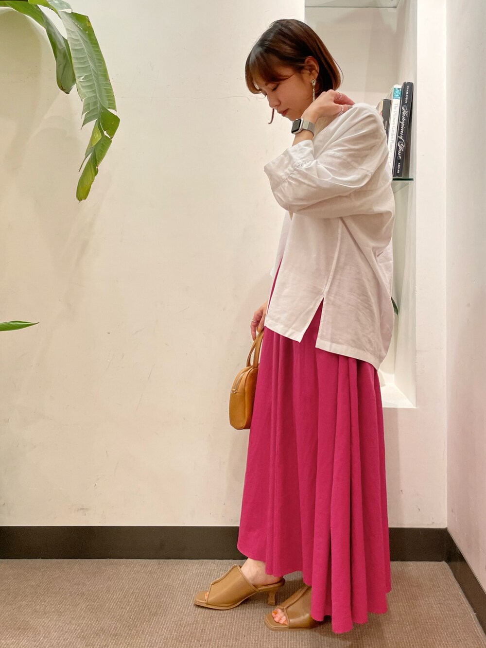 ピンク系のスカート、ホワイト系のシャツ/ブラウス、ホワイト系のニット/セーターを着用したレディースの夏コーディネートの3枚目の写真