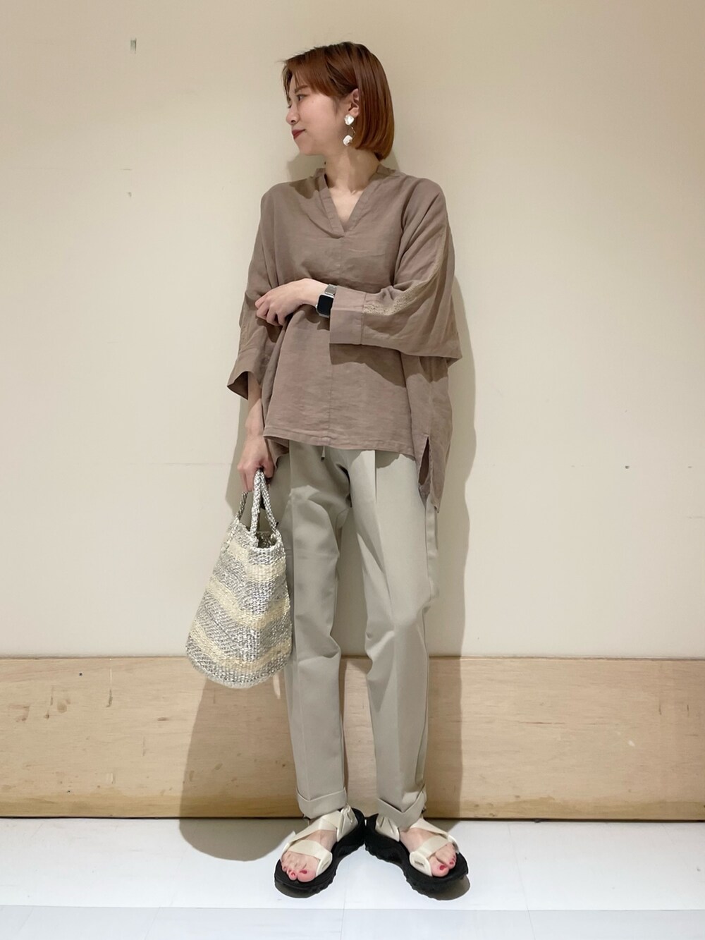 ベージュ系のその他パンツ、ホワイト系のハンドバッグ、ホワイト系のサンダルを着用したレディースの夏コーディネートの2枚目の写真