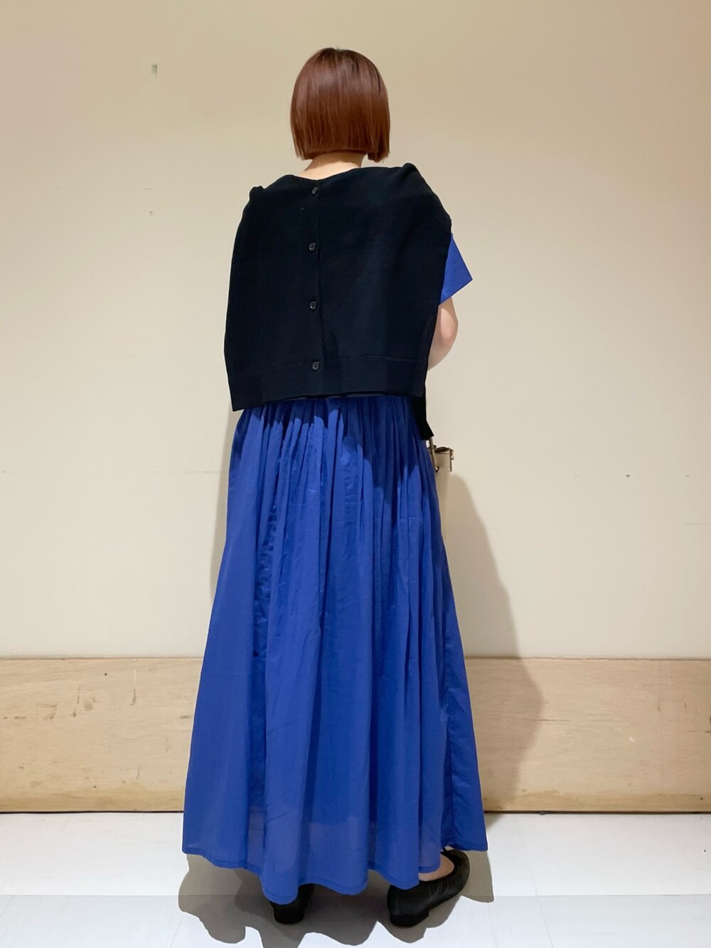 ブルー系のワンピース、ブラック系のカーディガン/ボレロ、ホワイト系のトートバッグを着用したレディースの春コーディネートの8枚目の写真