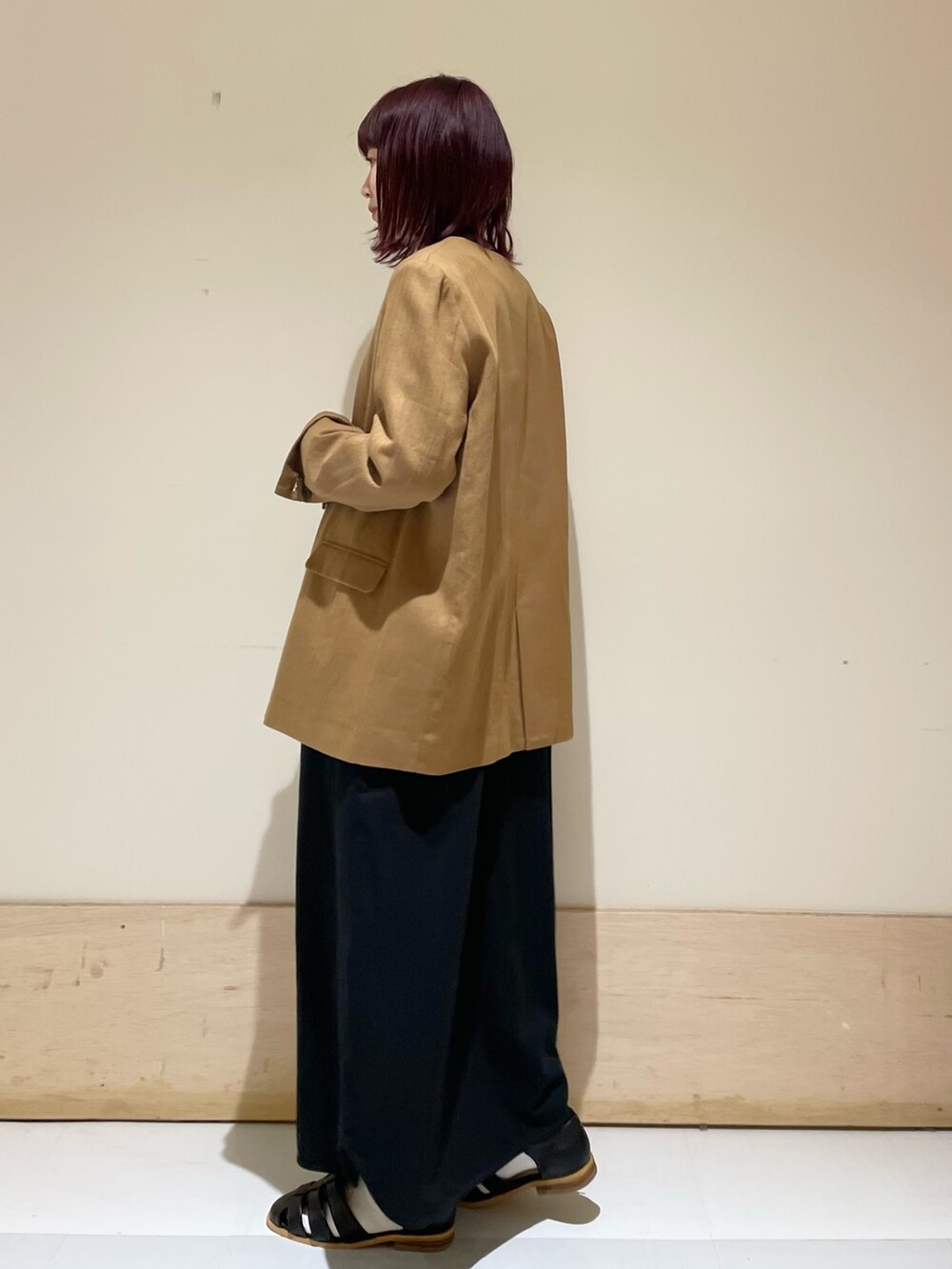 ブラック系のワンピース、ベージュ系のノーカラージャケット、ブラック系のサンダルを着用したレディースの春コーディネートの6枚目の写真