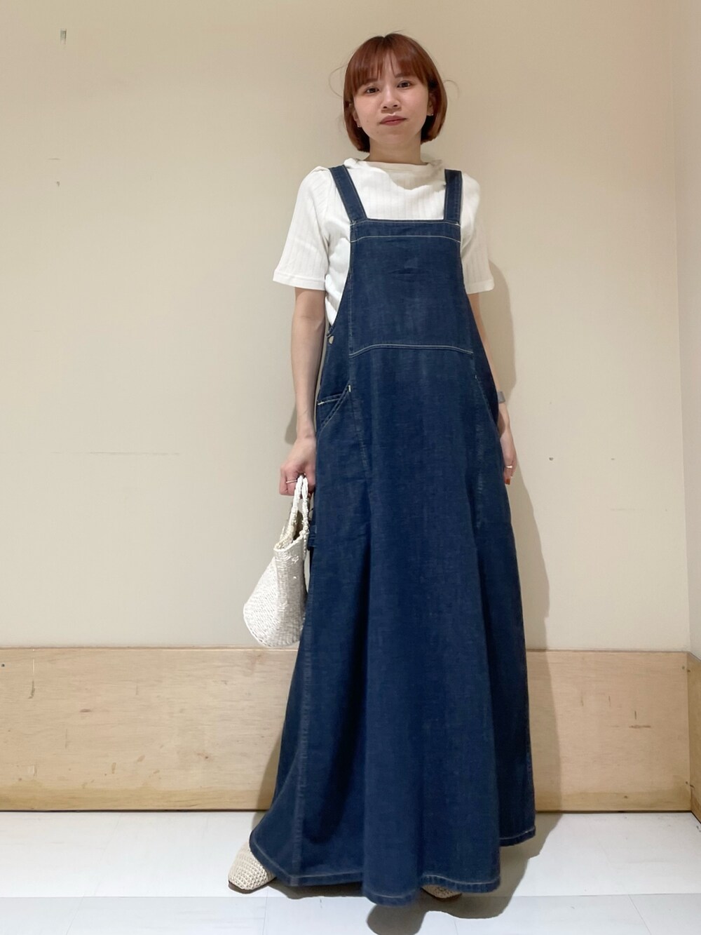 ホワイト系のハンドバッグ、ホワイト系のTシャツ/カットソー、ブルー系のワンピースを着用したレディースの春コーディネートの2枚目の写真