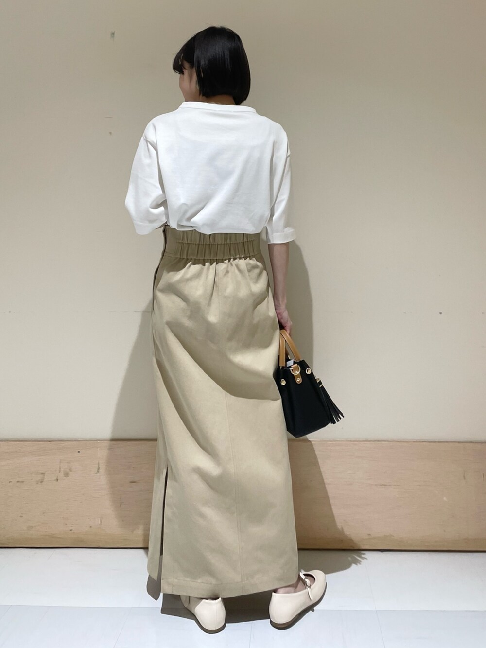 ホワイト系のTシャツ/カットソー、ブラック系のトートバッグ、ベージュ系のスカートを着用したレディースの夏コーディネートの6枚目の写真