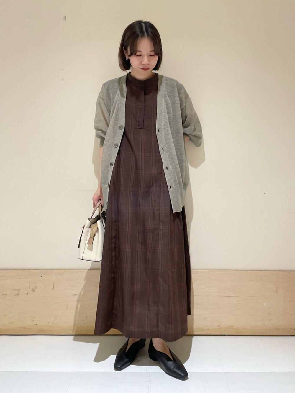 ブラウン系のワンピース、ベージュ系のカーディガン/ボレロ、ブラック系のパンプスを着用したレディースの夏コーディネートの3枚目の写真