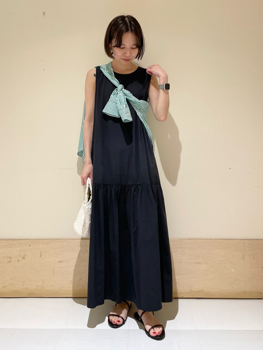 ブラック系のワンピース、グリーン系のシャツ/ブラウス、ホワイト系のハンドバッグを着用したレディースの夏コーディネートの2枚目の写真