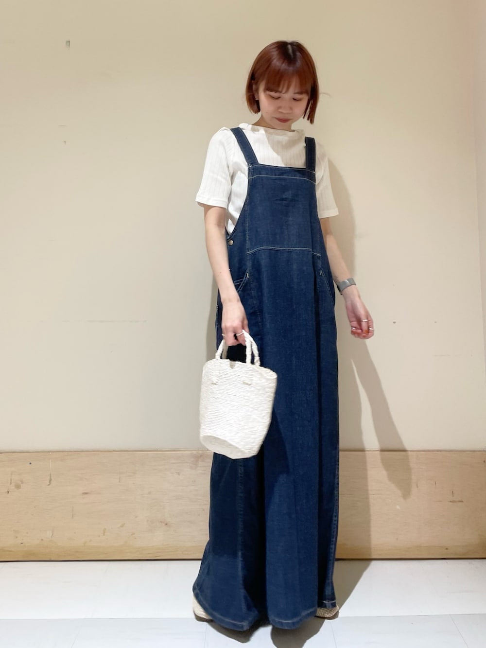 ホワイト系のハンドバッグ、ホワイト系のTシャツ/カットソー、ブルー系のワンピースを着用したレディースの春コーディネートの3枚目の写真