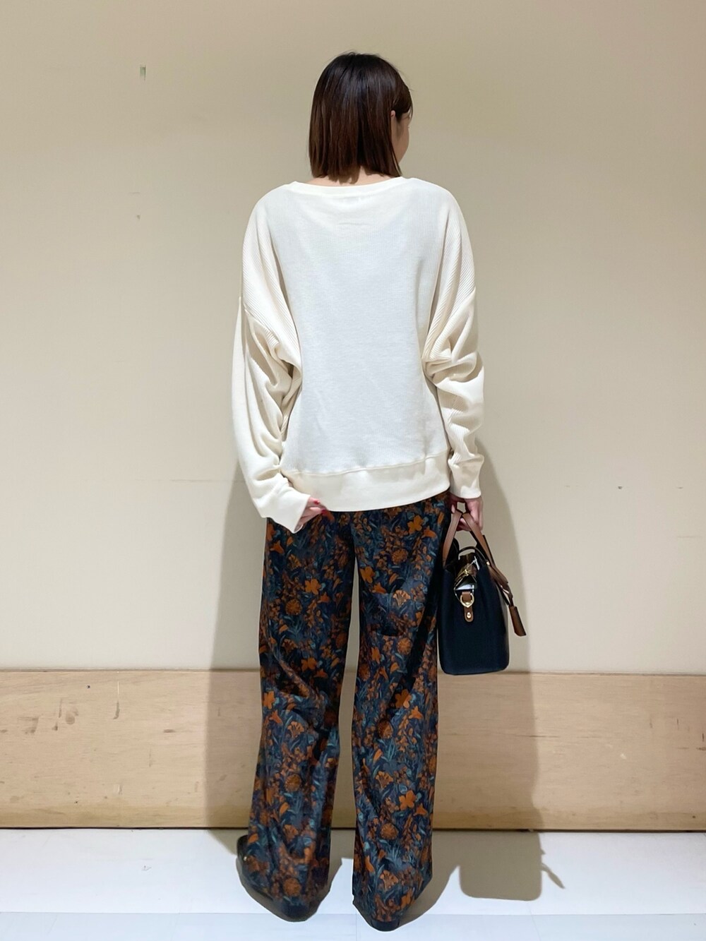 オレンジ系のその他パンツ、ブラック系のハンドバッグ、ブラック系のローファーを着用したレディースの秋コーディネートの7枚目の写真