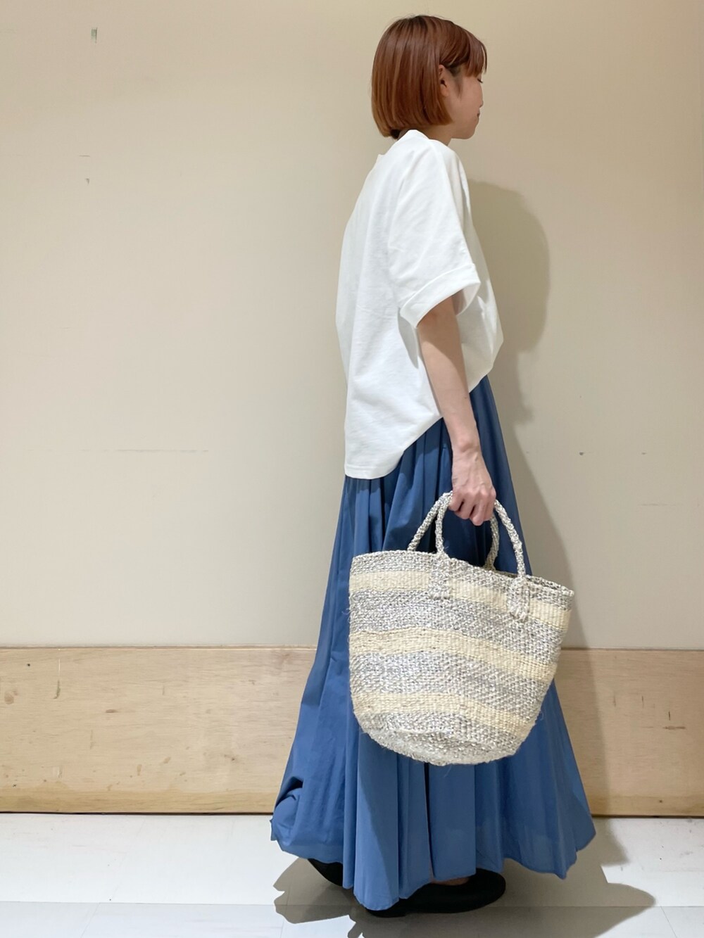 ホワイト系のTシャツ/カットソー、ブルー系のスカート、ホワイト系のハンドバッグを着用したレディースの夏コーディネートの4枚目の写真
