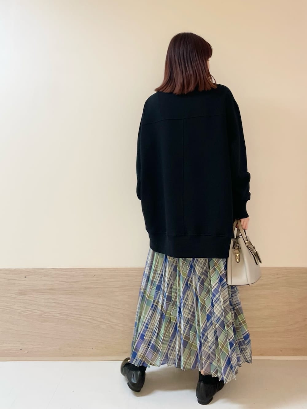 グリーン系のスカート、ブラック系のスウェットを着用したレディースの春コーディネートの7枚目の写真