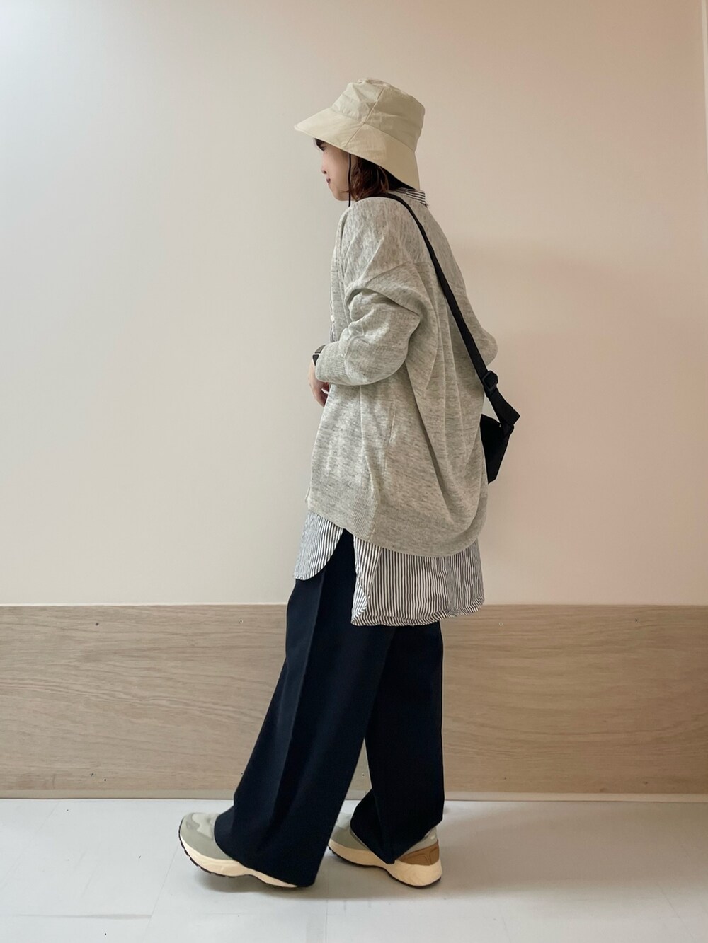 ブルー系のその他パンツ、グレー系のスニーカー、ブラック系のショルダーバッグを着用したレディースの春コーディネートの5枚目の写真