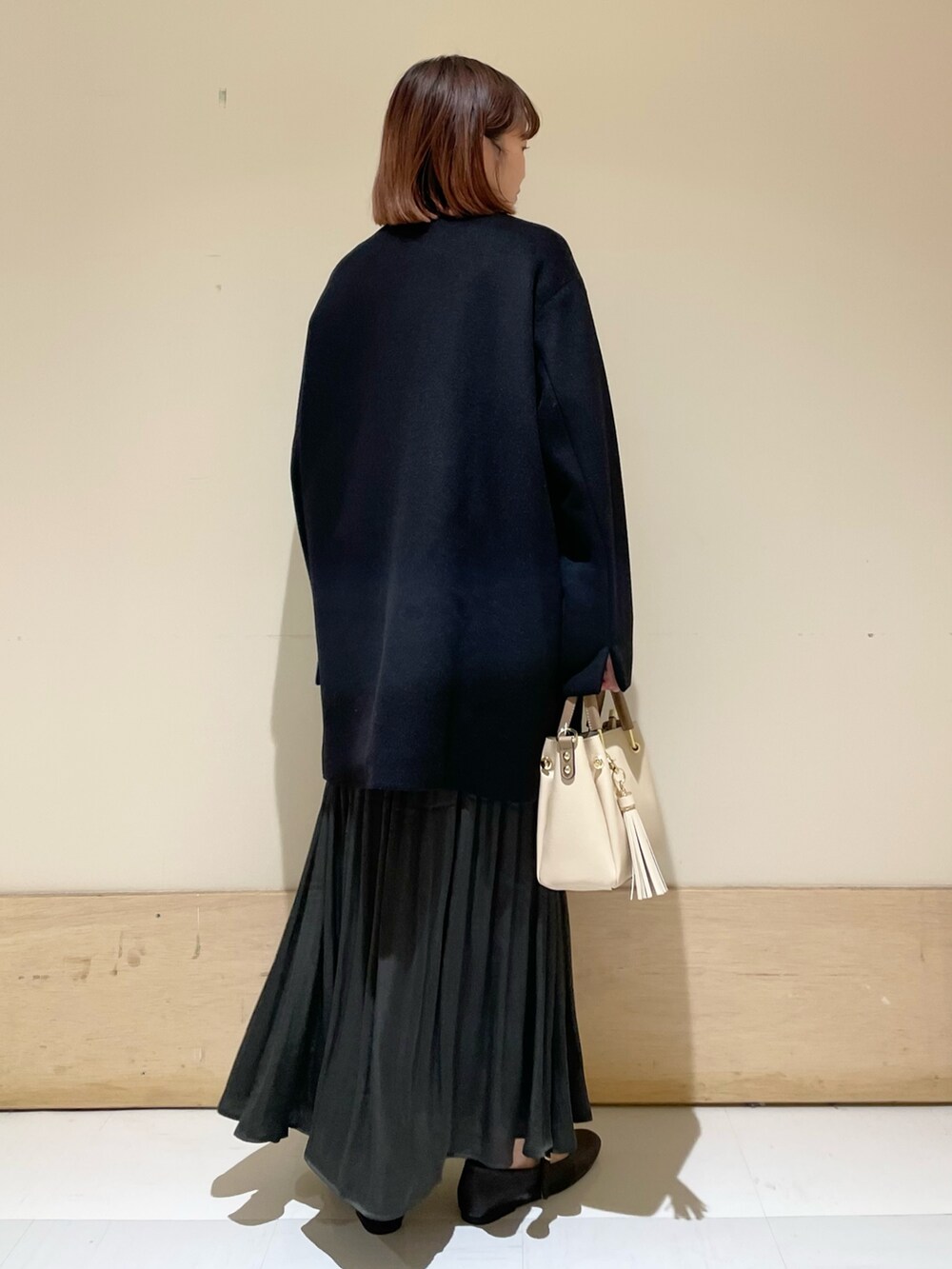 グリーン系のスカート、グレー系のニット/セーター、ブラック系のその他アウターを着用したレディースの冬コーディネートの8枚目の写真