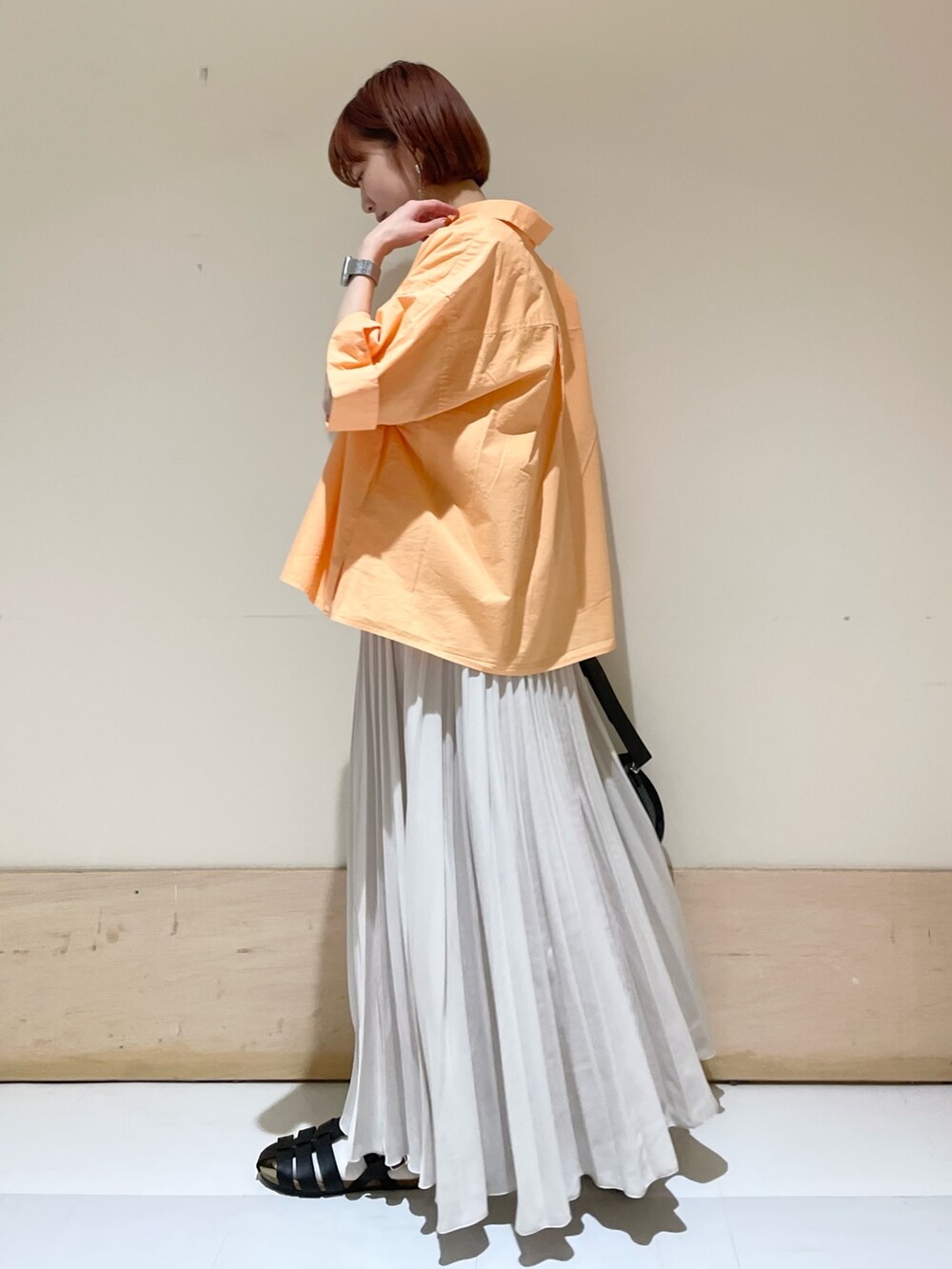 ブラック系のショルダーバッグ、ブラック系のサンダル、ホワイト系のスカートを着用したレディースの春コーディネートの5枚目の写真