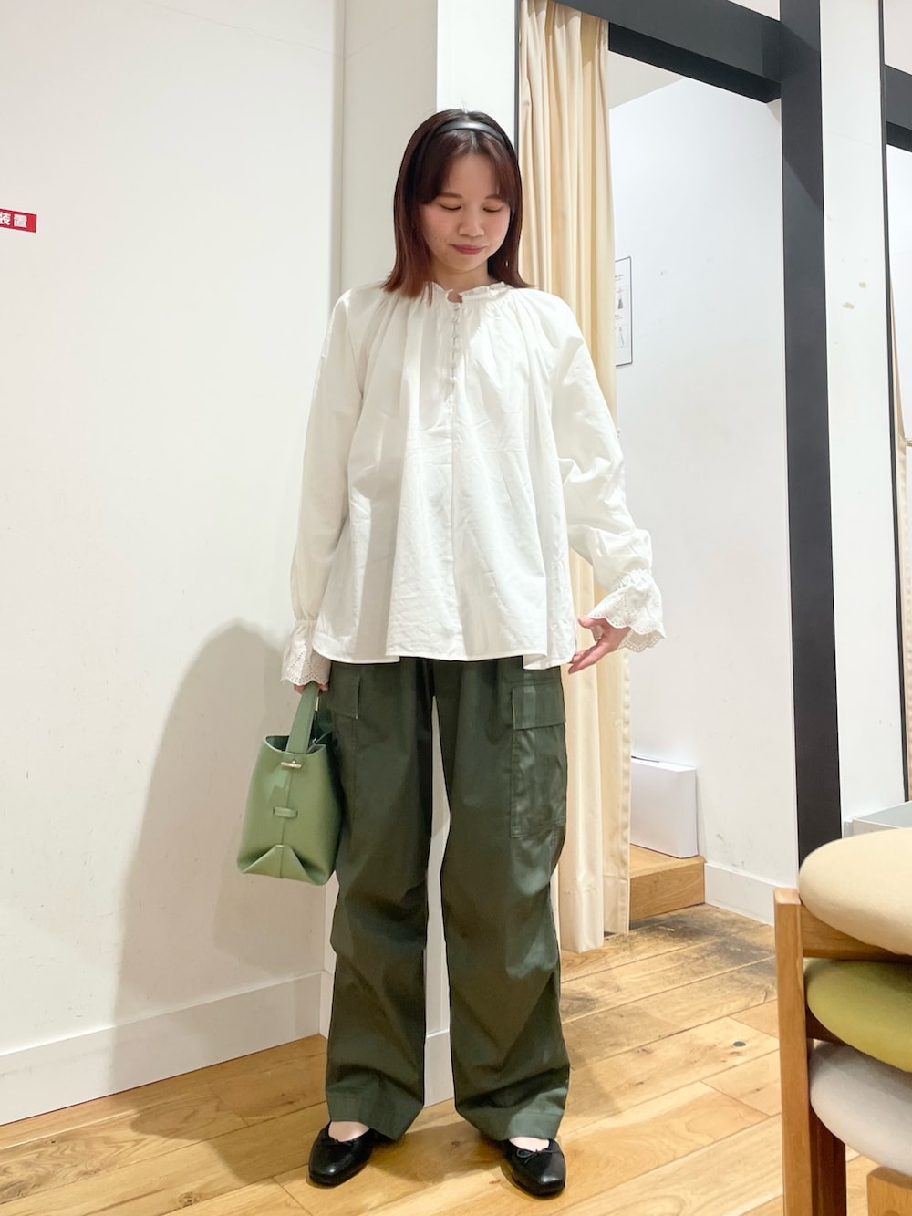 ホワイト系のシャツ/ブラウス、グリーン系のショルダーバッグ、ブラック系のバレエシューズを着用したレディースの春コーディネートの3枚目の写真