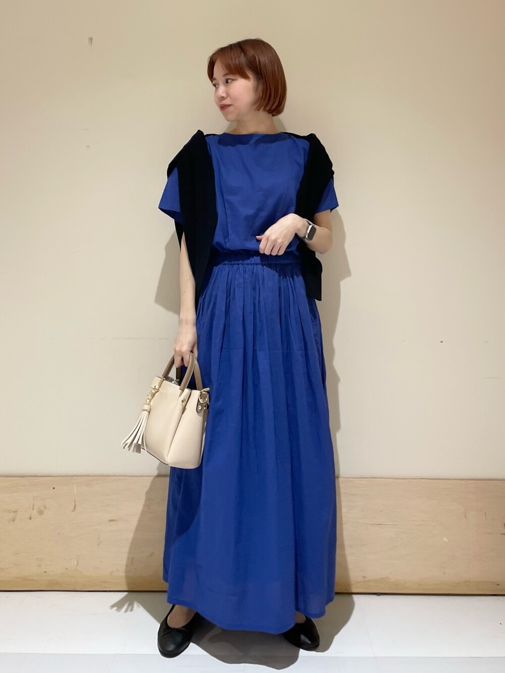 ブルー系のワンピース、ブラック系のカーディガン/ボレロ、ホワイト系のトートバッグを着用したレディースの春コーディネートの3枚目の写真