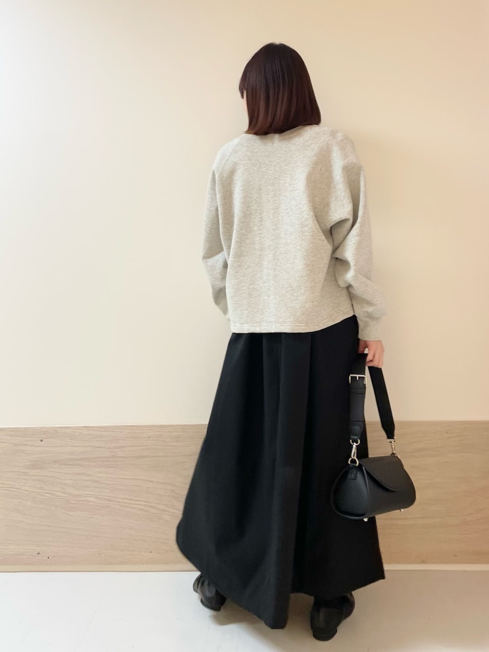 グレー系のカーディガン/ボレロ、イエロー系のニット/セーター、ブラック系のワンピースを着用したレディースの春コーディネートの5枚目の写真