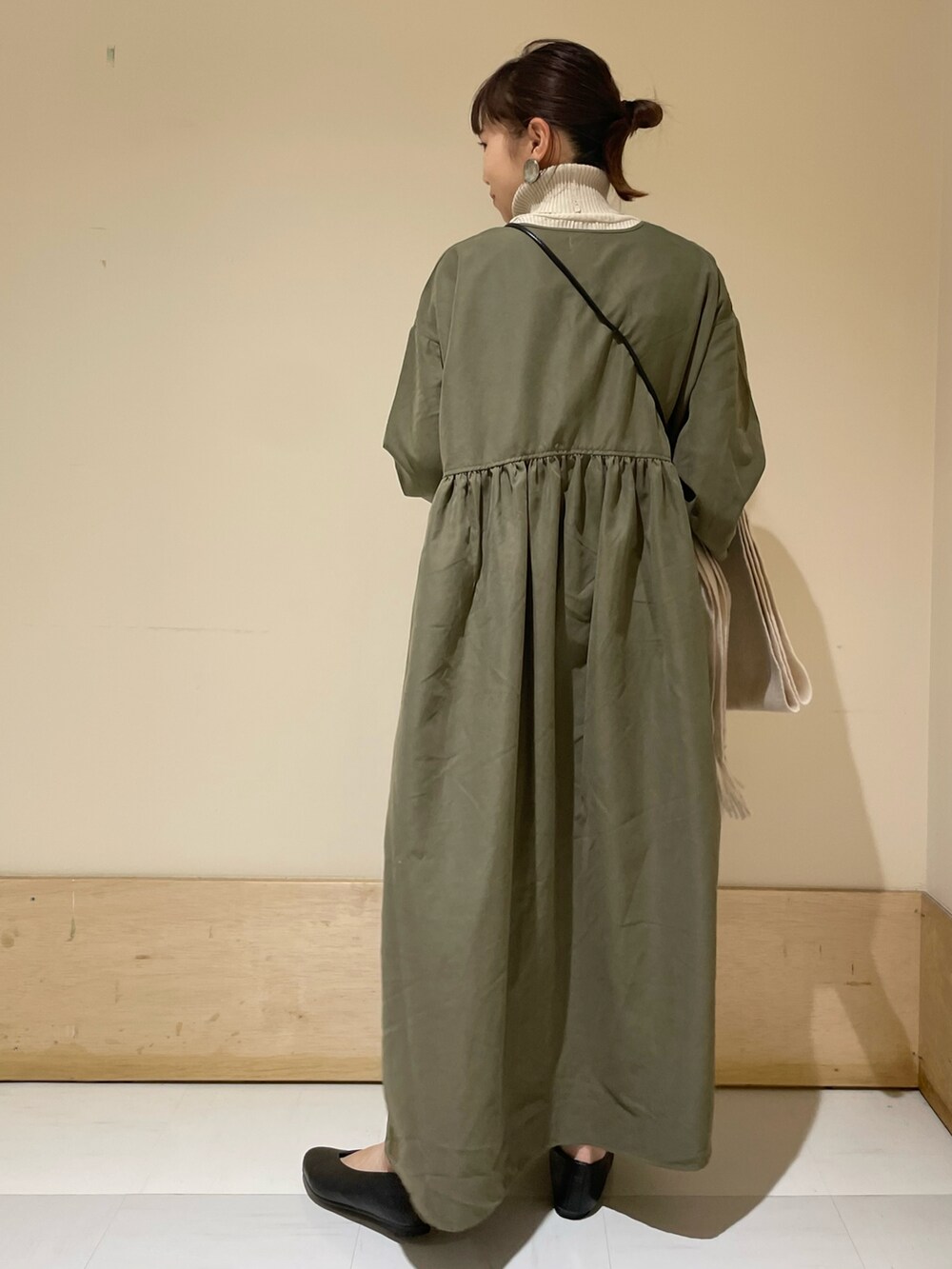 ブラック系のショルダーバッグ、グリーン系のワンピース、グレー系のニット/セーターを着用したレディースの冬コーディネートの3枚目の写真