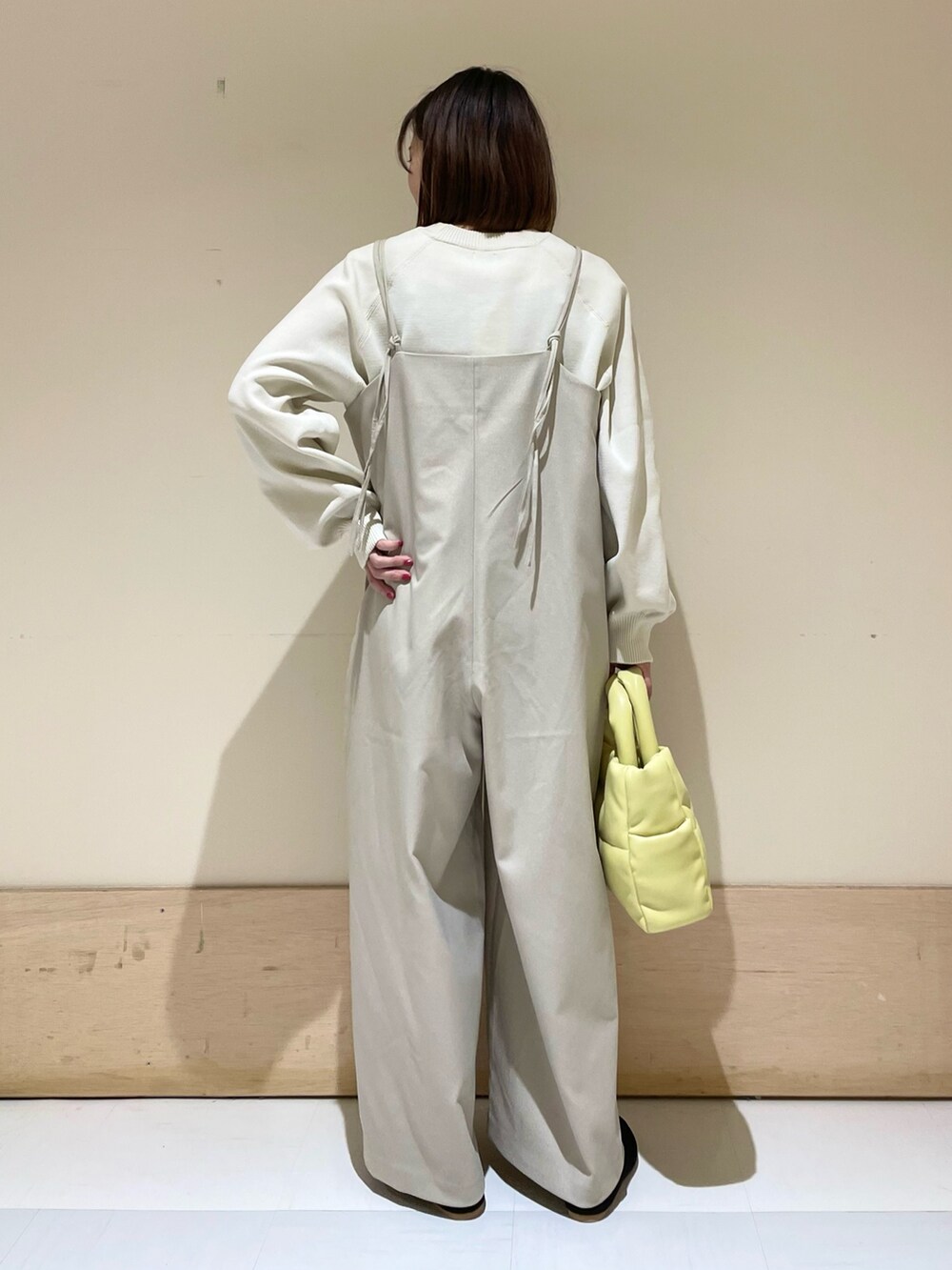 ホワイト系のニット/セーター、ベージュ系のサロペット/オーバーオール、イエロー系のトートバッグを着用したレディースの秋コーディネートの6枚目の写真