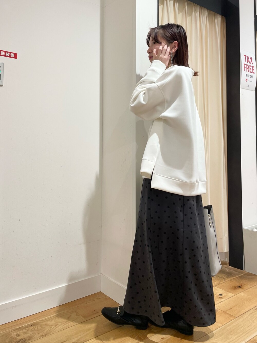 ホワイト系のTシャツ/カットソー、グレー系のスカートを着用したレディースの春コーディネートの6枚目の写真