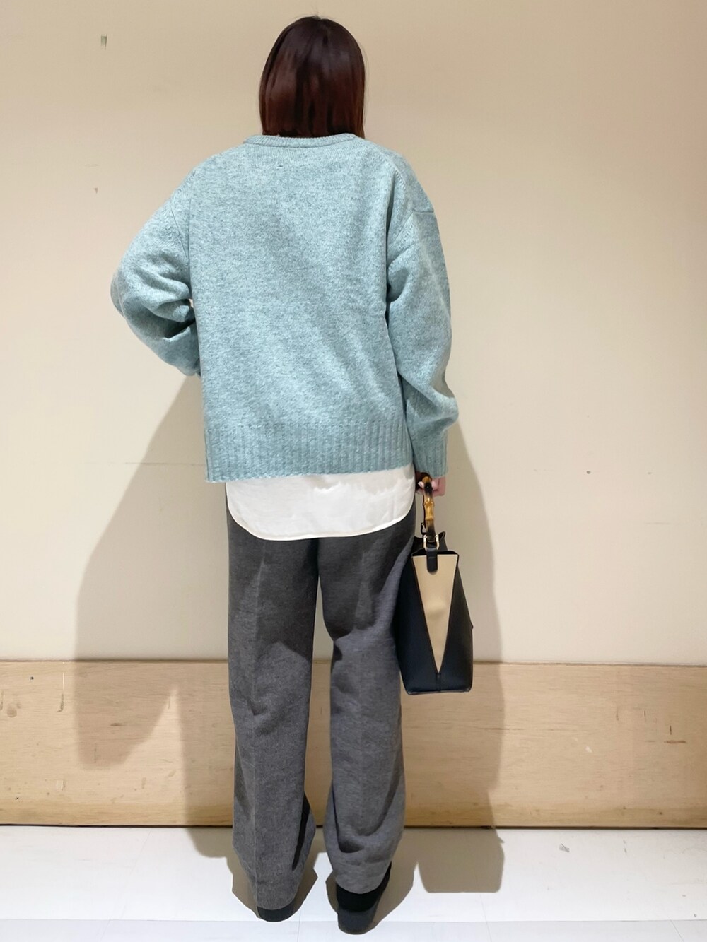 グリーン系のニット/セーター、ホワイト系のTシャツ/カットソー、グレー系のその他パンツを着用したレディースの冬コーディネートの7枚目の写真