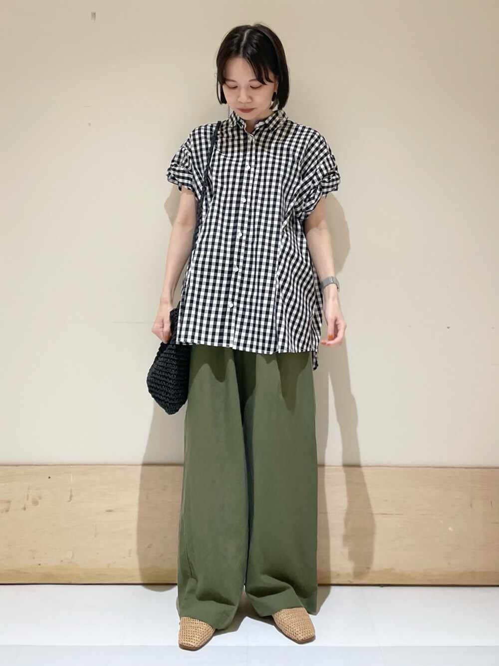 ブラック系のショルダーバッグ、ベージュ系のバレエシューズ、グリーン系のその他パンツを着用したレディースの夏コーディネートの3枚目の写真