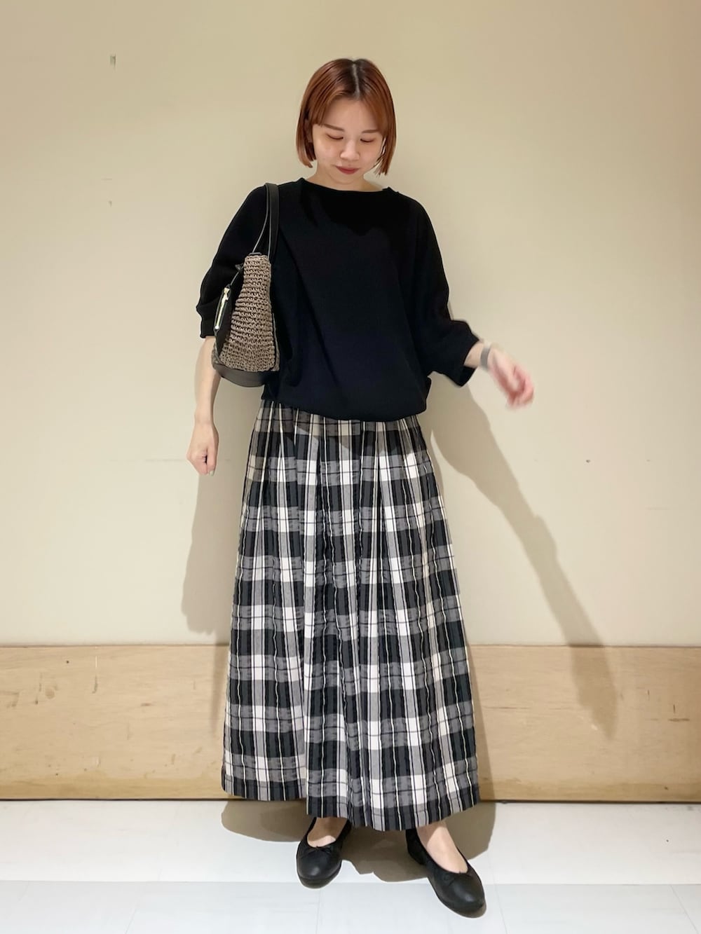 ブラック系のTシャツ/カットソー、ブラック系のスカート、グレー系のトートバッグを着用したレディースの春コーディネートの2枚目の写真