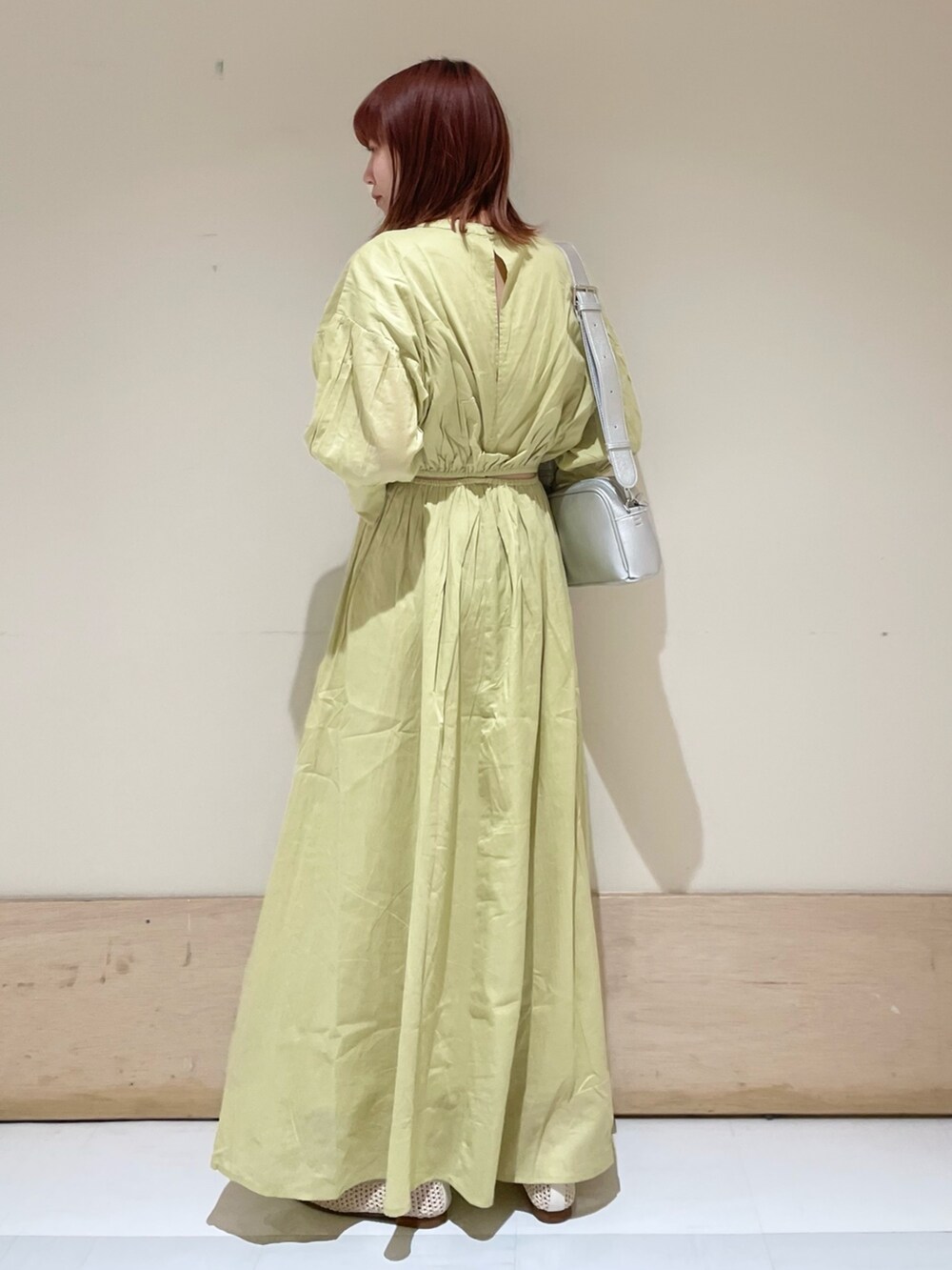 グリーン系のワンピース、シルバー系のショルダーバッグ、ホワイト系のパンプスを着用したレディースの春コーディネートの6枚目の写真