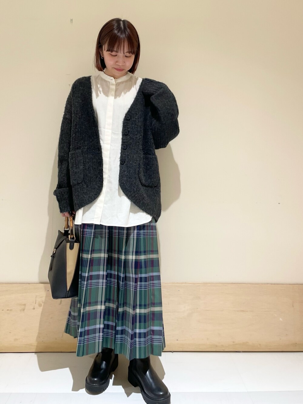 ホワイト系のシャツ/ブラウス、ブラック系のカーディガン/ボレロ、ブラック系のブーツを着用したレディースの秋コーディネートの3枚目の写真