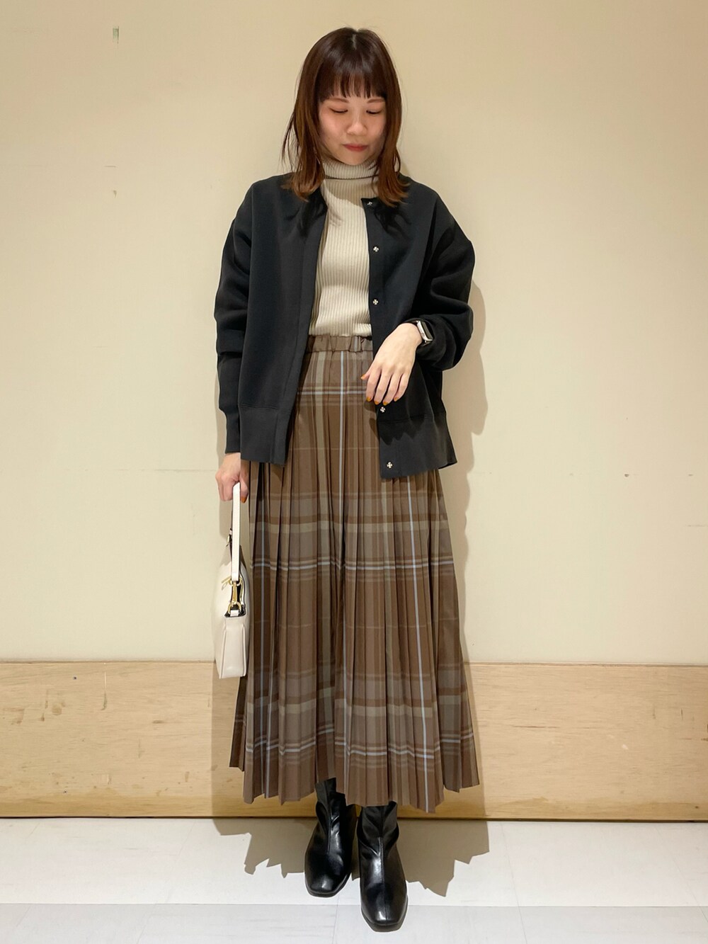 ブラウン系のスカート、グレー系のカーディガン/ボレロ、グレー系のニット/セーターを着用したレディースの冬コーディネートの2枚目の写真