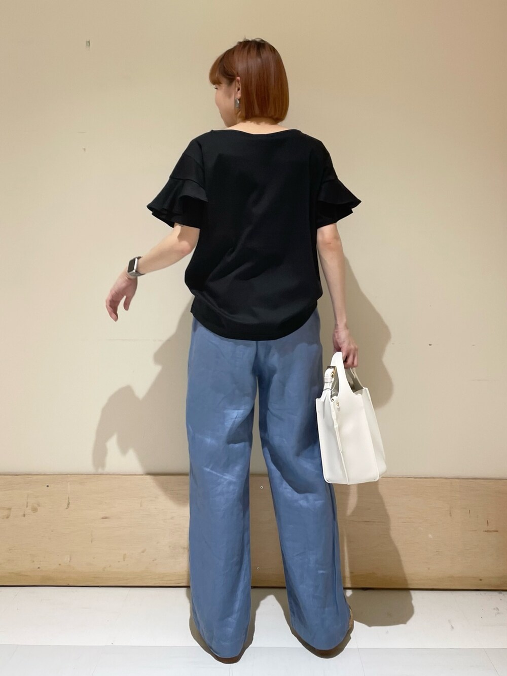 ブラック系のTシャツ/カットソー、ホワイト系のトートバッグ、ブルー系のその他パンツを着用したレディースの春コーディネートの6枚目の写真