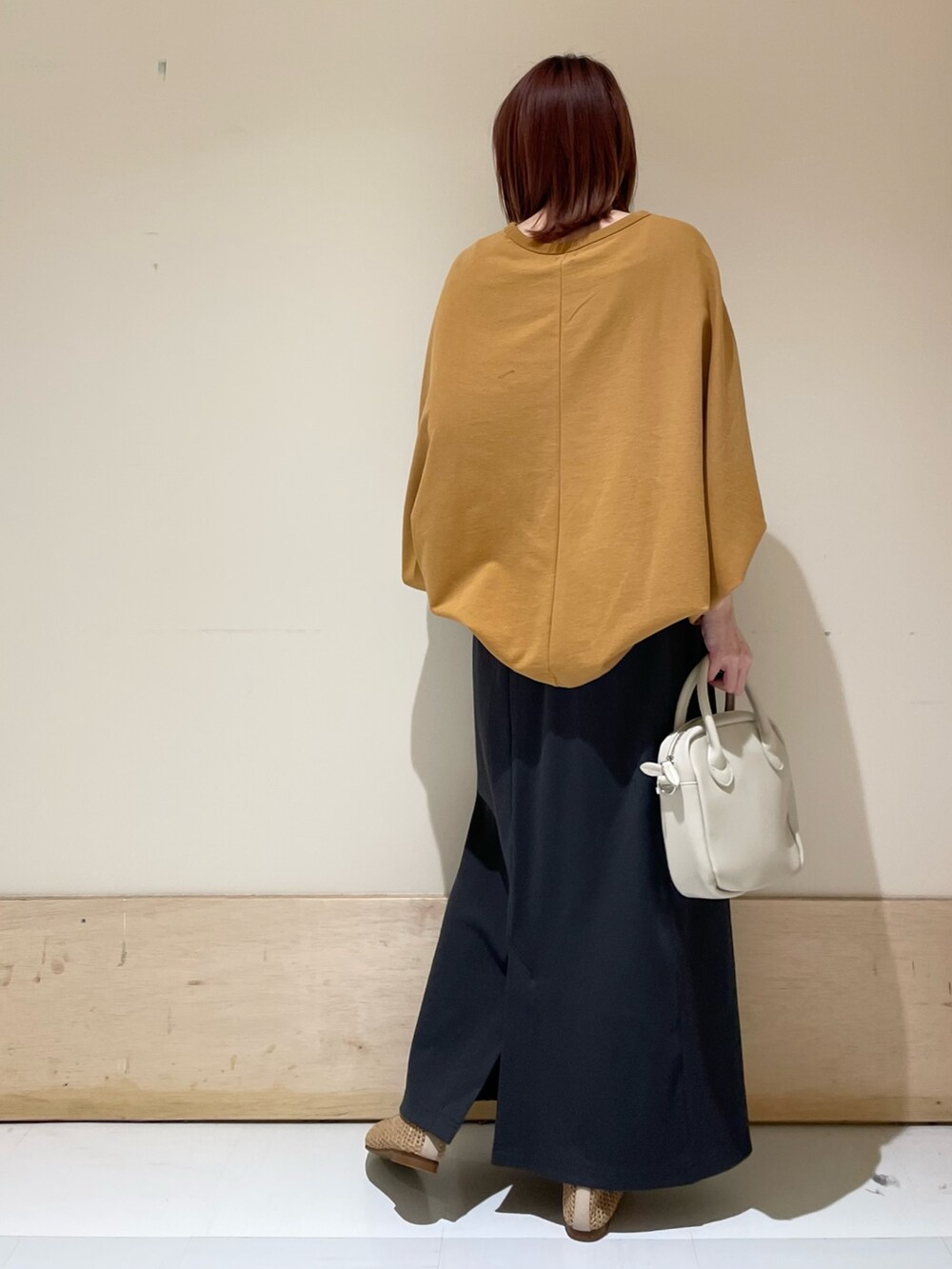 イエロー系のTシャツ/カットソー、ベージュ系のパンプス、グレー系のスカートを着用したレディースの春コーディネートの7枚目の写真