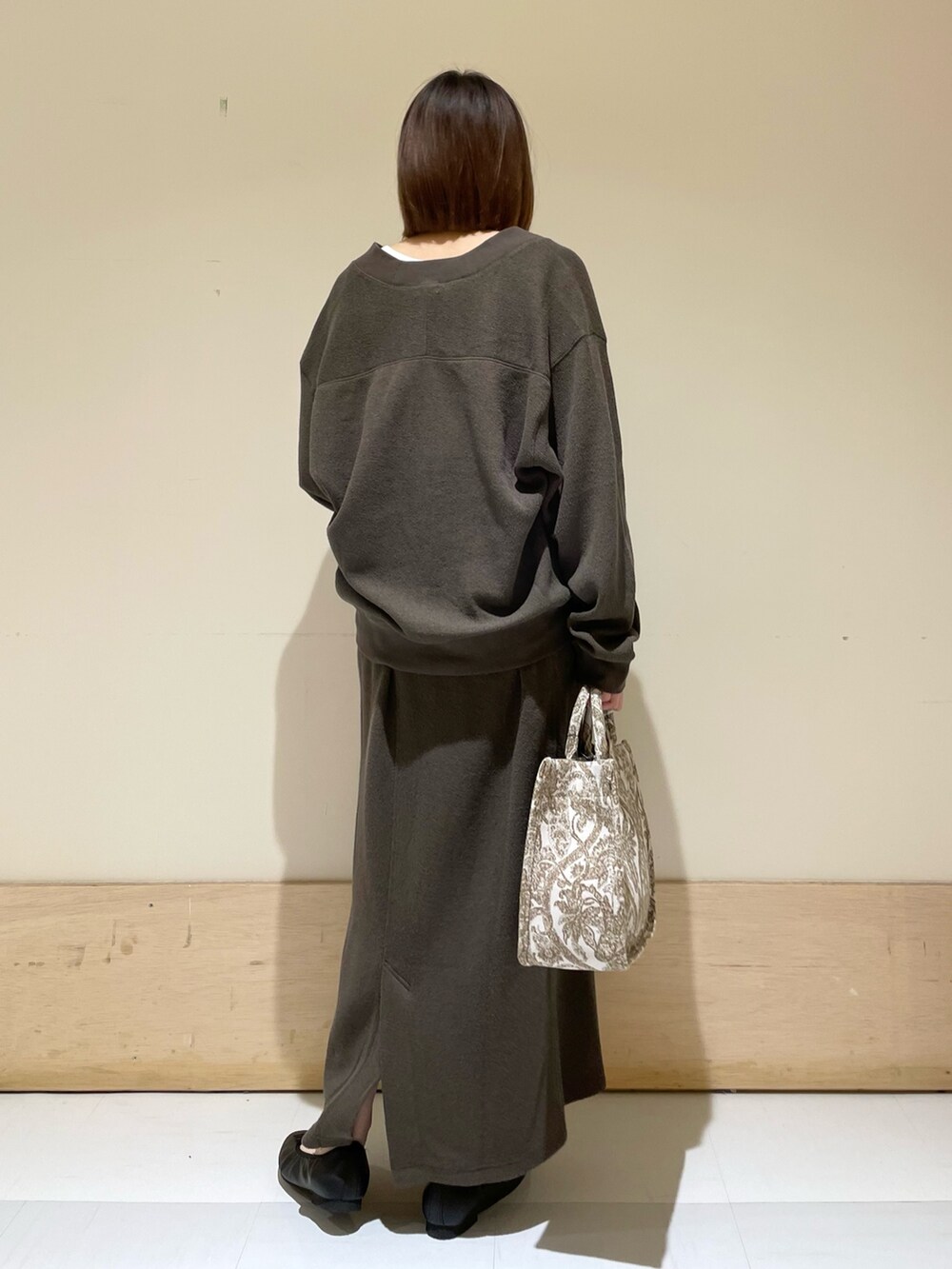 ベージュ系のトートバッグ、ホワイト系のタンクトップ、グレー系のカーディガン/ボレロを着用したレディースの秋コーディネートの7枚目の写真