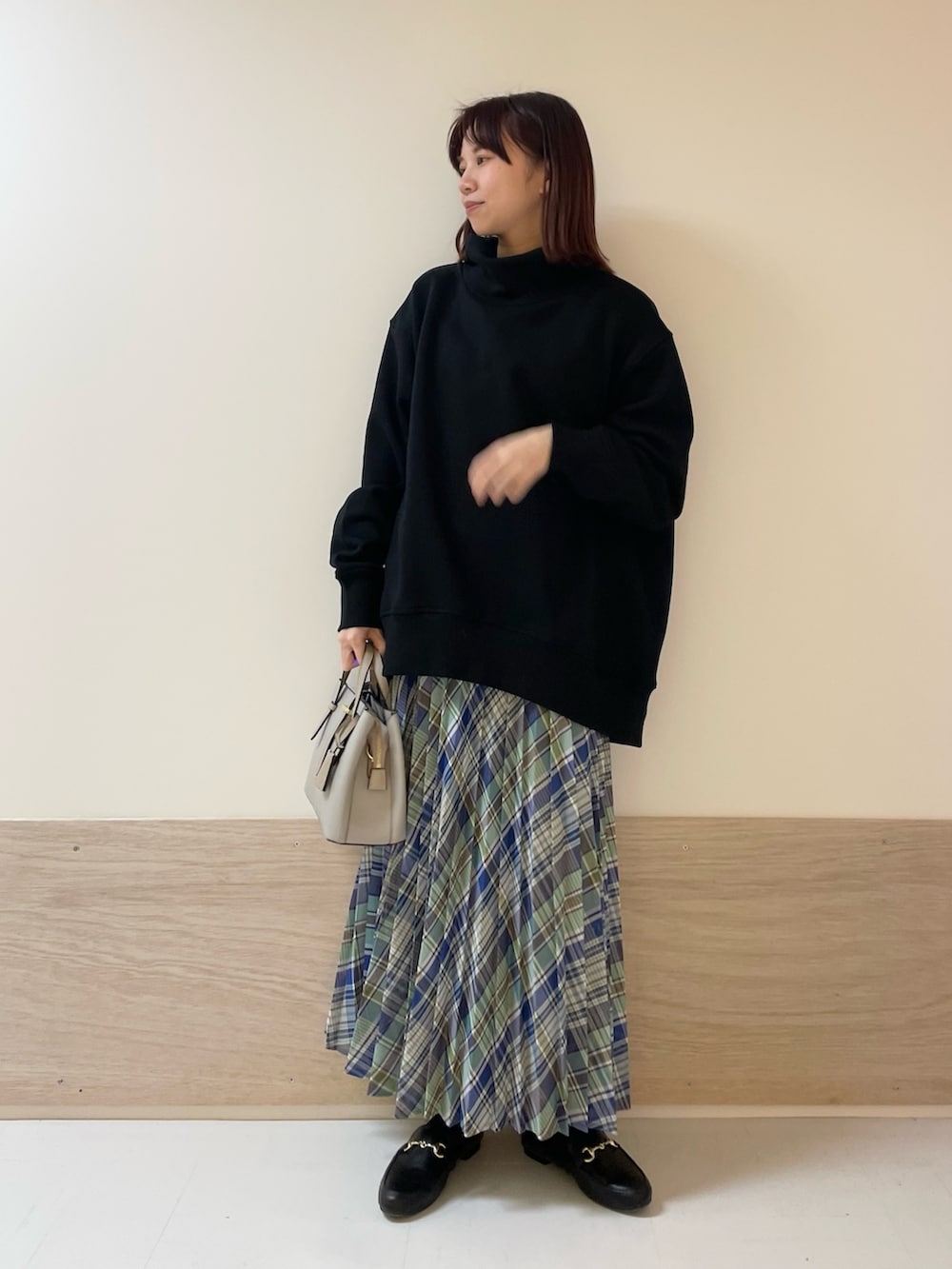 グリーン系のスカート、ブラック系のスウェットを着用したレディースの春コーディネートの2枚目の写真