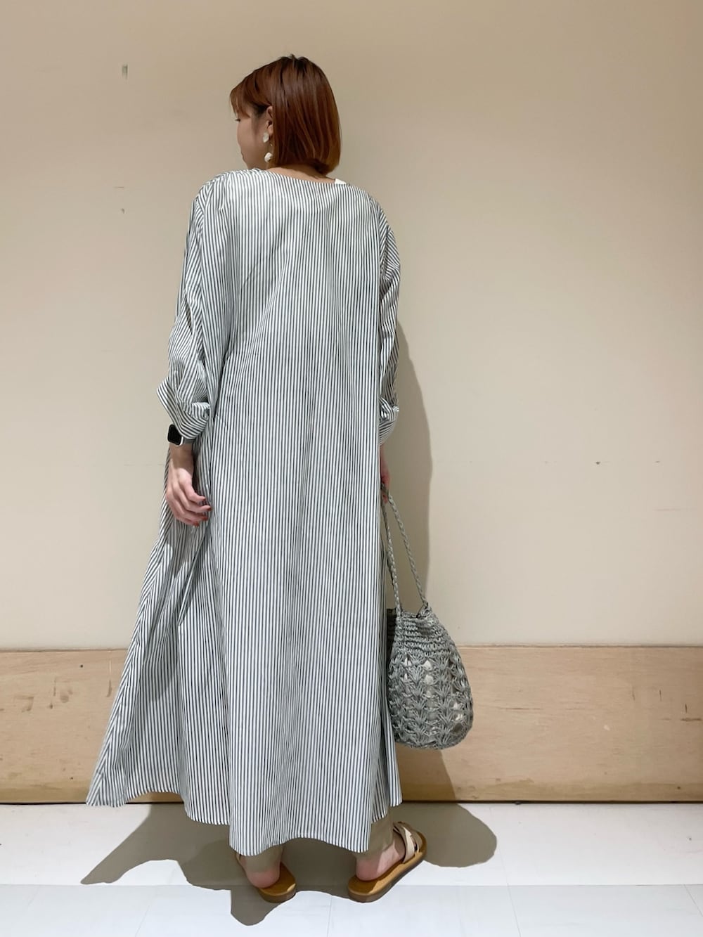 グリーン系のワンピース、グリーン系のかごバッグ、ベージュ系のその他パンツを着用したレディースの夏コーディネートの7枚目の写真