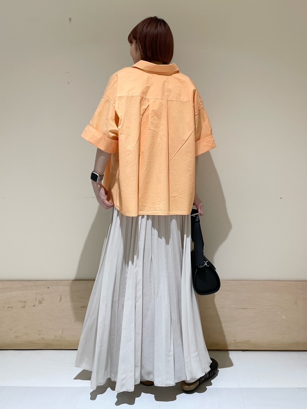 ブラック系のショルダーバッグ、ブラック系のサンダル、ホワイト系のスカートを着用したレディースの春コーディネートの7枚目の写真