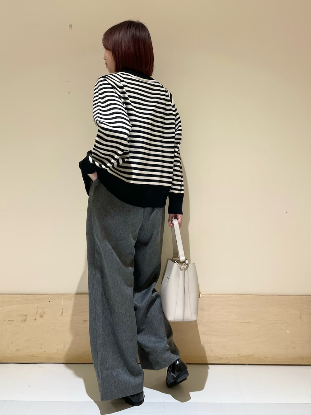 グレー系のその他パンツ、グレー系のハンドバッグ、ブラック系のパンプスを着用したレディースの秋コーディネートの5枚目の写真