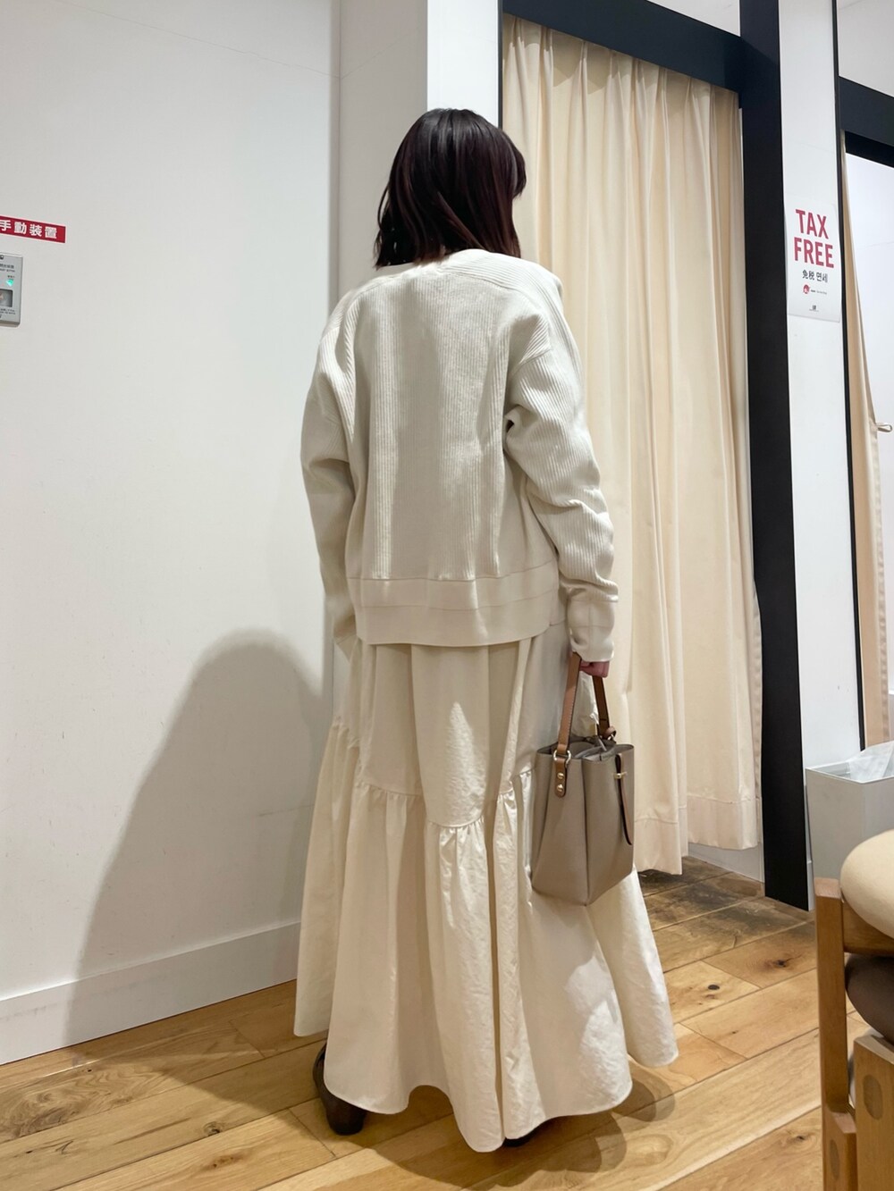 ホワイト系のカーディガン/ボレロ、ブラック系のTシャツ/カットソー、ホワイト系のスカートを着用したレディースの春コーディネートの7枚目の写真