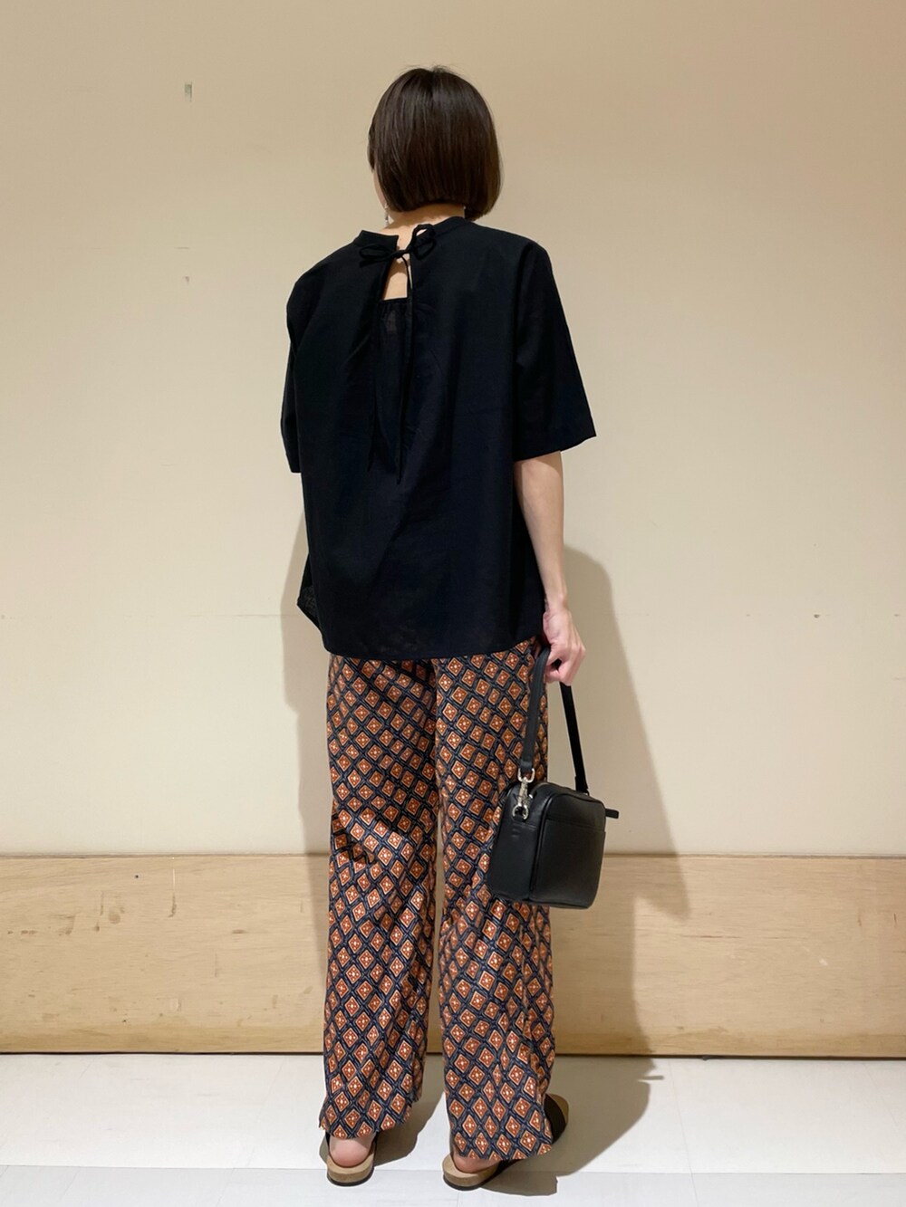 ブラック系のサンダル、ブラック系のショルダーバッグ、ブルー系のその他パンツを着用したレディースの夏コーディネートの7枚目の写真