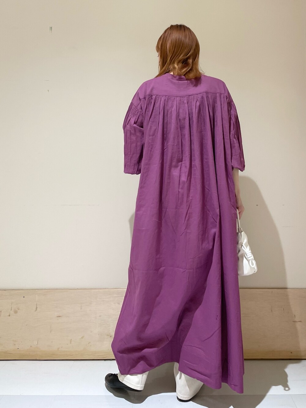 ベージュ系のデニムパンツ、パープル系のワンピース、ホワイト系のショルダーバッグを着用したレディースの春コーディネートの6枚目の写真