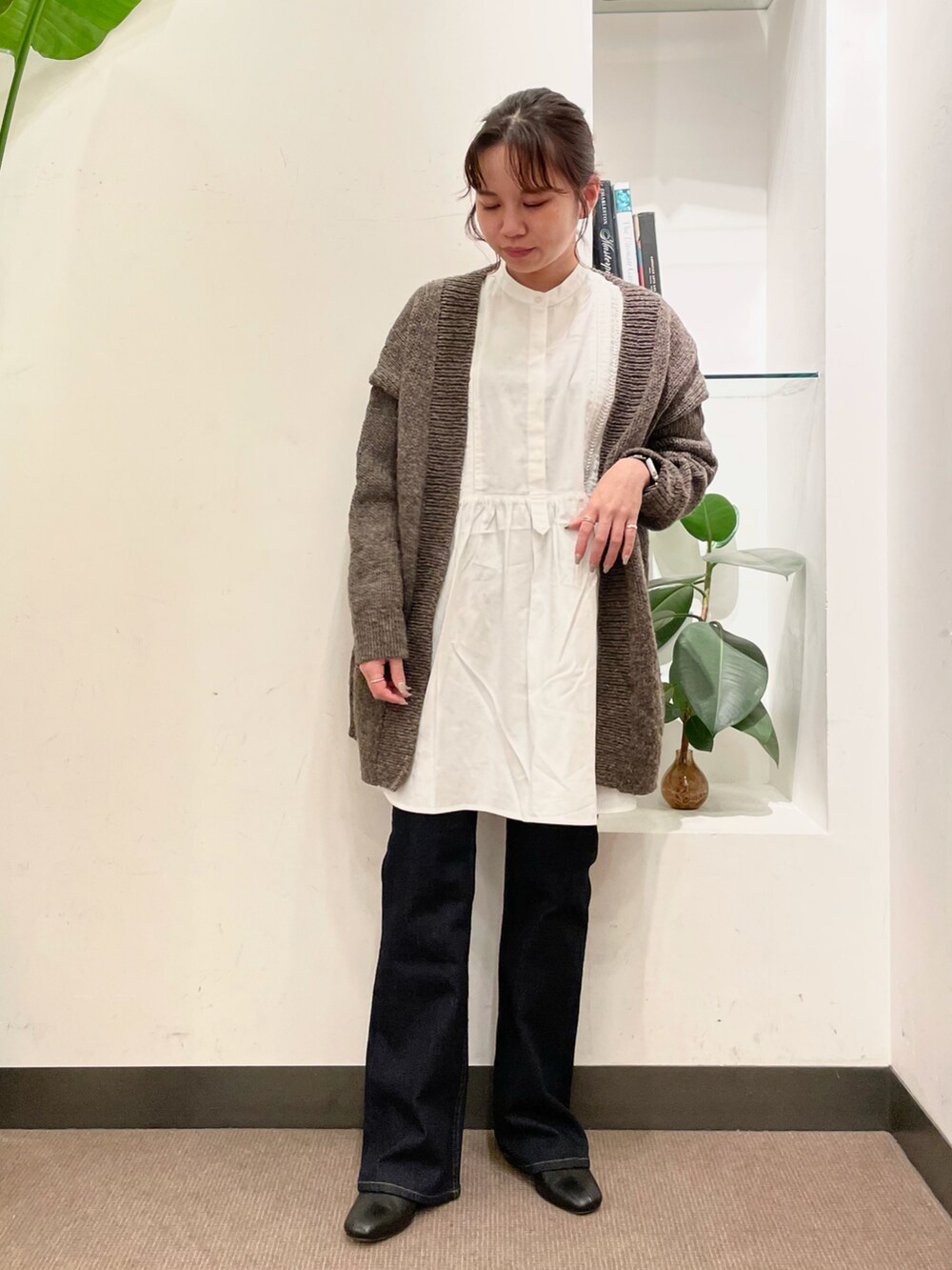 グレー系のカーディガン/ボレロ、ホワイト系のシャツ/ブラウス、ブルー系のデニムパンツを着用したレディースの秋コーディネートの2枚目の写真