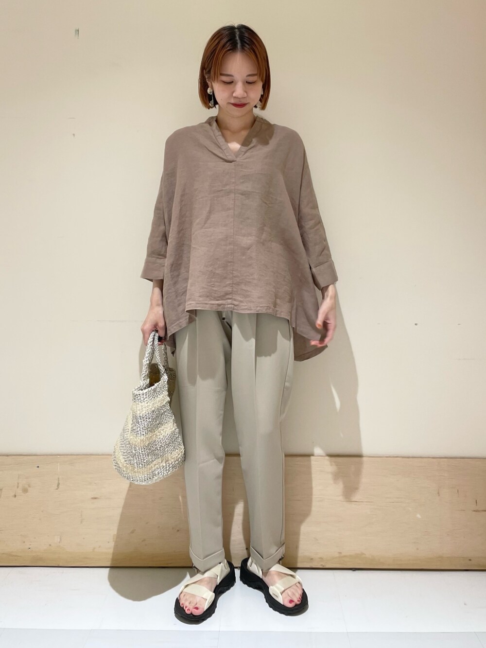 ベージュ系のその他パンツ、ホワイト系のハンドバッグ、ホワイト系のサンダルを着用したレディースの夏コーディネートの3枚目の写真