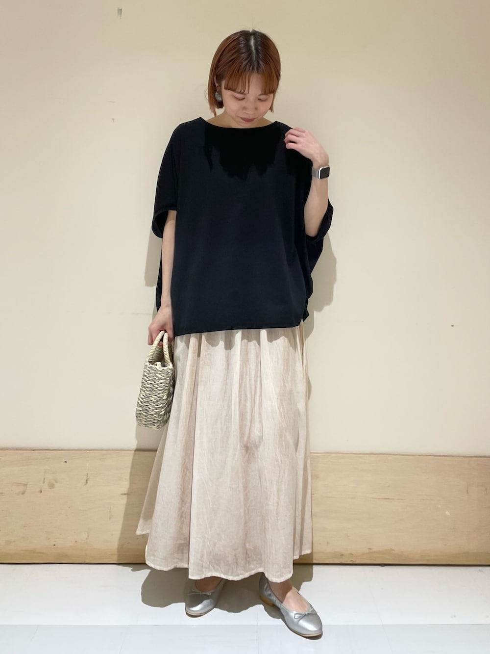 グレー系のかごバッグ、シルバー系のバレエシューズ、ブラック系のTシャツ/カットソーを着用したレディースの春コーディネートの3枚目の写真