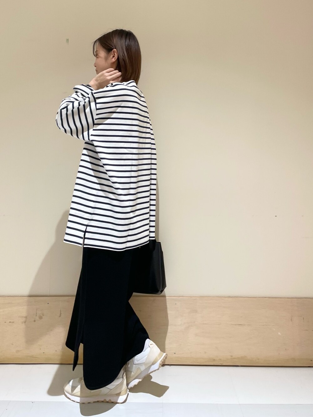 ブルー系のTシャツ/カットソー、ブラック系のスカート、ブラック系のトートバッグを着用したレディースの秋コーディネートの5枚目の写真