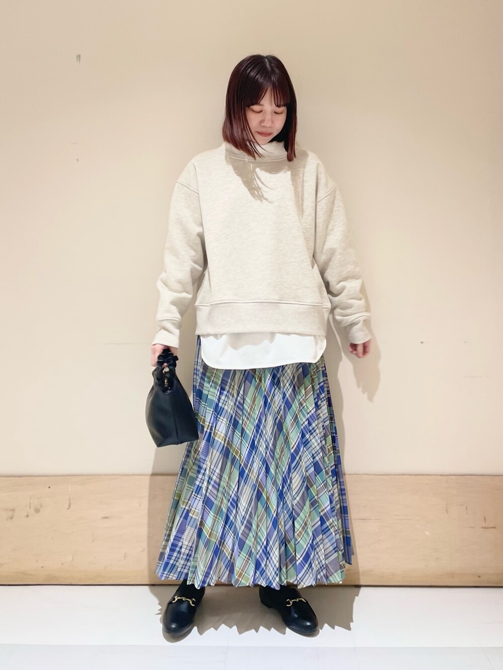 グリーン系のスカート、グレー系のTシャツ/カットソー、ホワイト系のTシャツ/カットソーを着用したレディースの冬コーディネートの3枚目の写真